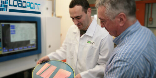 Lab technician showing customer precision cut optical material