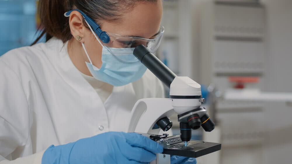 Scientist looking through microscope